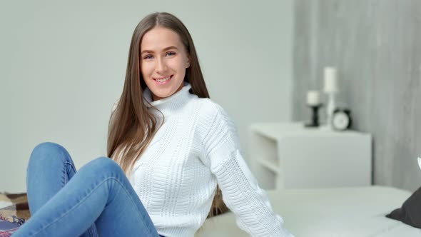 Medium Long Shot Charming Young Woman Smiling Sitting on Bed in Modern Bedroom