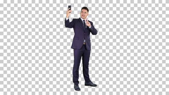 Happy young handsome businessman recording vlog with his phone