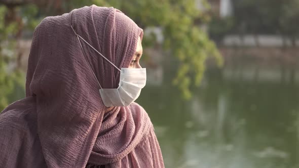 Side View of Muslim Woman with Flu Mask at Park