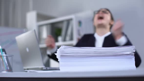 Worker Shouting and Throwing Papers in Despair, Extensive Workload, Breakdown