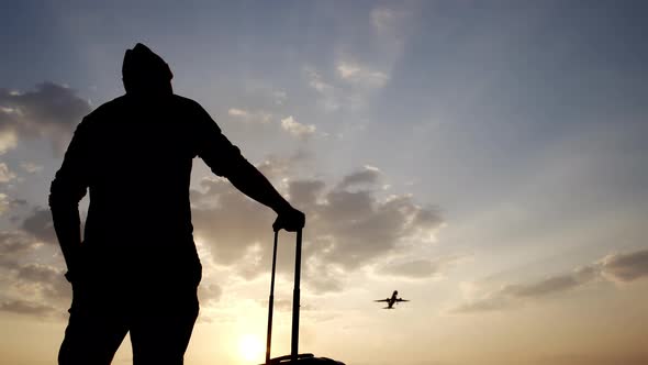 Man with a Suitcase at the Airport at Sunset