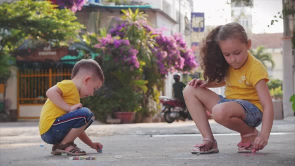 Funny Little Children Like To Play a Fun Game Together, Making Drawings with Colored Crayons