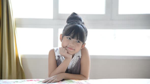 Little Asian Girl Thinking Under Light From Window