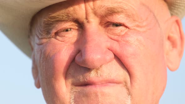 Portrait of a Tired Old Grandfather with Wrinkles Against a Blue Sky