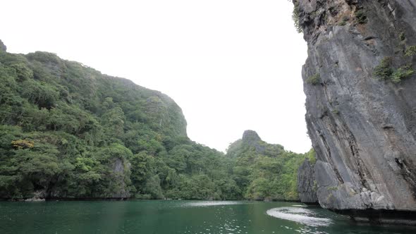 Slow motion dolly shot sailing in the famous Big Lagoon surrounded by limestone cliffs in El Nido, P