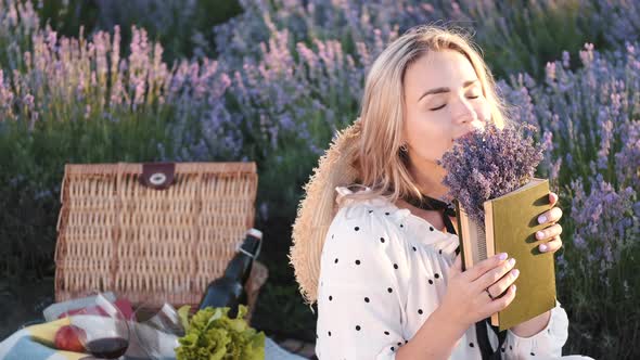 Pretty Blond Woman in a Dress Sitting in the Lavender Field