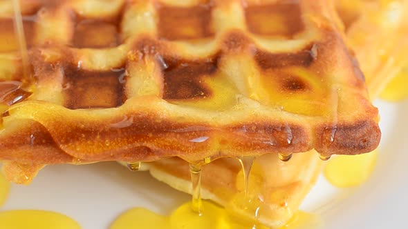 Preparation of waffles. Waffles are watered with honey.