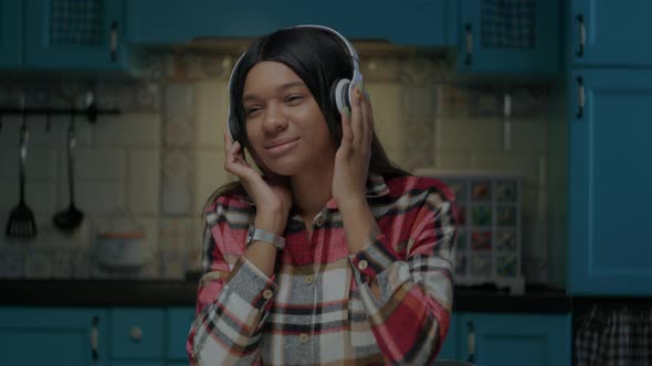 Young African American Woman Wearing Wireless Headphones Enjoying Listening the Music Sitting at