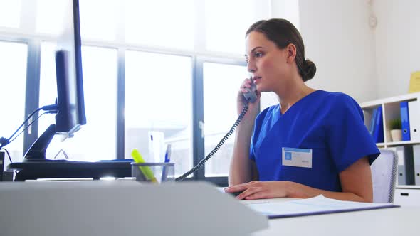 Doctor with Computer Calling on Phone at Hospital