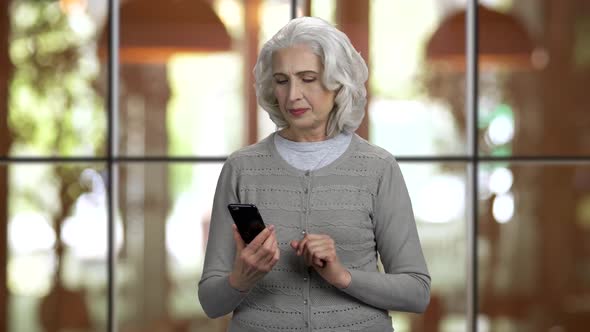 Happy Old Greyhaired Lady Using Her Smartphone