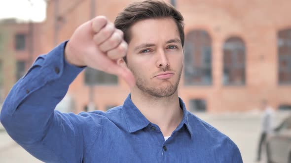 Thumbs Down By Young Man Standing Outdoor