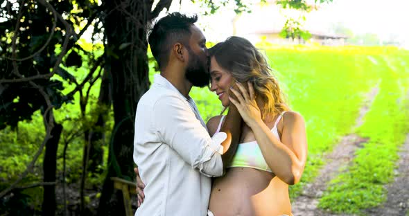 Pregnant mom's happiness when receiving a passionate kiss on her husband's forehead. Fix camera