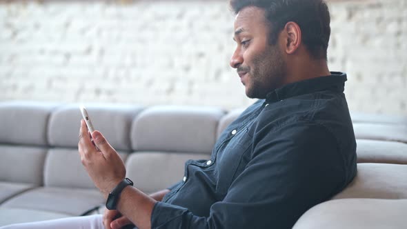 Multiethnic Hindu Freelancer Guy Using Smartphone for Video Call