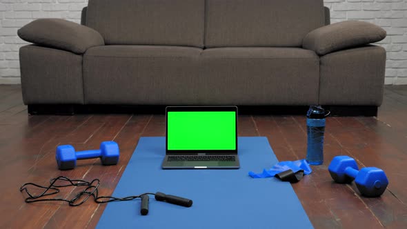 Laptop Display Green Screen Stand on Fitness or Yoga Mat on Home Sofa Background