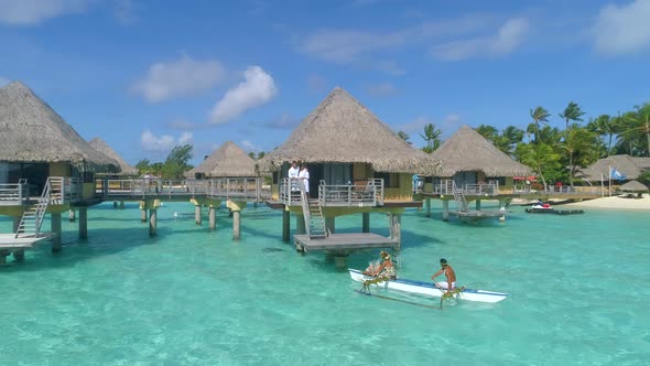 A man and woman couple on a outrigger canoe boat in Bora Bora tropical island.
