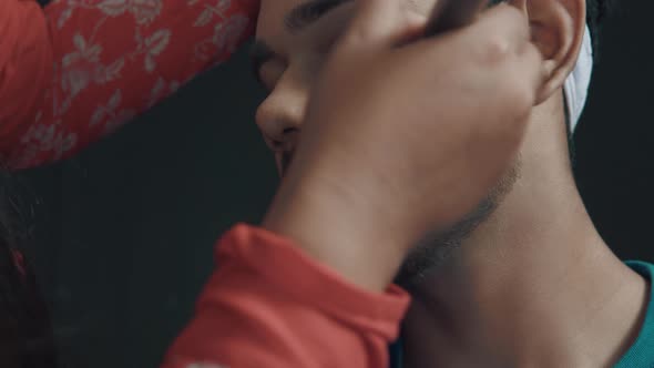 Close up of make up artist doing the make up on man's face putting a powder on his  face