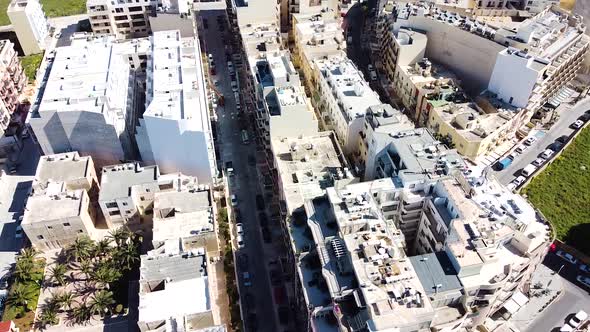 Multi-story living buildings and narrow streets of St. Paul Bay in Malta, aerial view