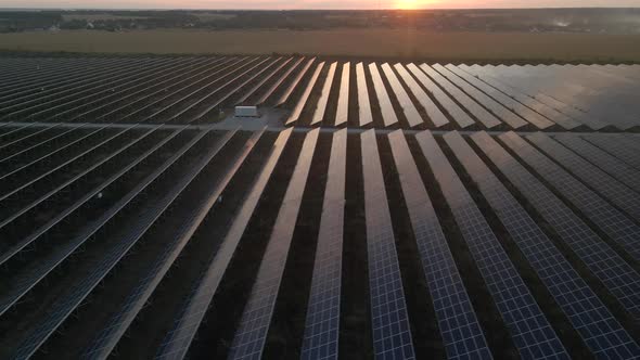 Aerial Drone View Into Large Solar Panels at a Solar Farm at Bright Sunset. Solar Cell Power Plants