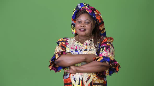 Overweight Beautiful African Woman Wearing Traditional Clothing Against Green Background