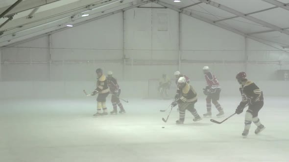 Men playing ice hockey in a skating rink.