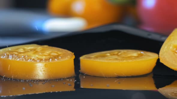 Delicious yellow tomato slices sprinkled with salt macro