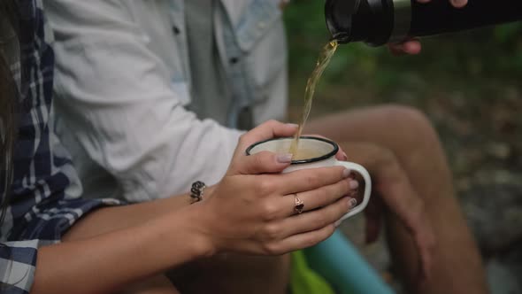 Forest Camp Tourists are Drinking Tea Man is Pouring Hot Drink for Woman