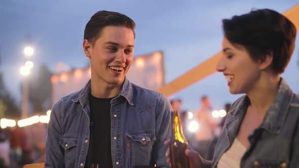 Couple At Party, Drinking Beer And Communicating Outdoors