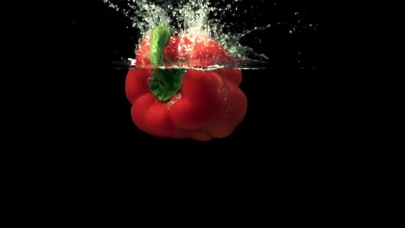 Super Slow Motion Pepper Falls Under the Water with Splashes and Air Bubbles