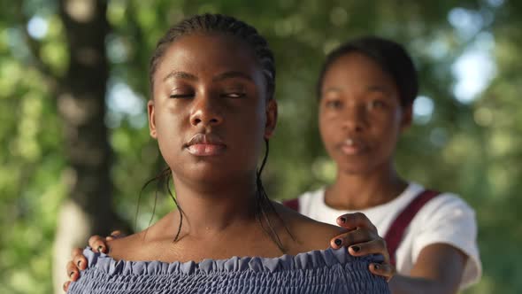 Beautiful African American Sad Woman in Summer Park Looking Away As Friend Touching Shoulders