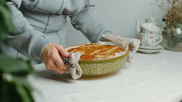 Housewife Puts Baking Dish for Banana Pie on Table 