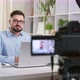 A male vlogger records video on a camera while sitting at a table at home - VideoHive Item for Sale