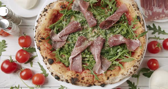 Delicious Pizza with Prosciutto Parma Ham Arugula Salad Rocket with Ingredients