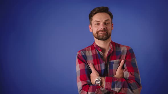 Handsome Caucasian Man with Crossed Arms Smiling Isolated on the Blue Background