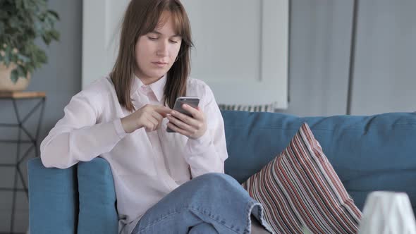 Relaxing Young Woman Using Smartphone
