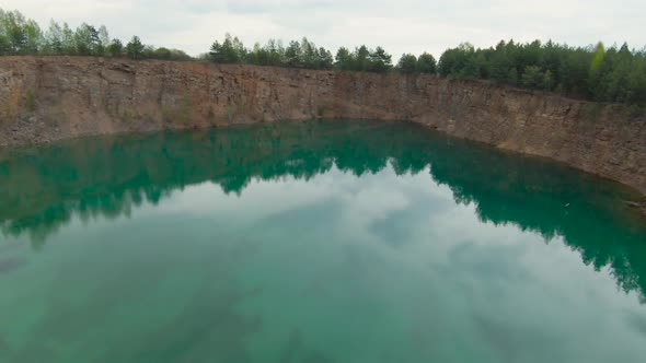 Flight Over the Turquoise Surface of the Lake in the Center of the Quarry