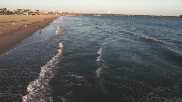 Drone footage of Seal Beach in Orange County California with ocean waves crashing into the sand