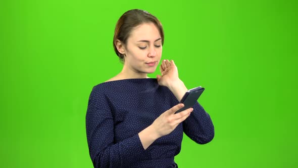 Girl Holding a Phone Dials a Message and Paces . Green Screen