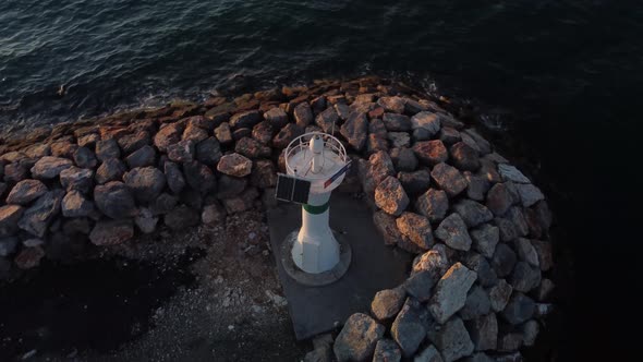 Panorama Drone Shot of a Lighthouse at Golden Hour with Ocean and Sun