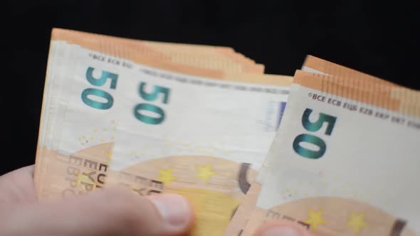 A man counts money - euro banknotes with a face value of 50 euros