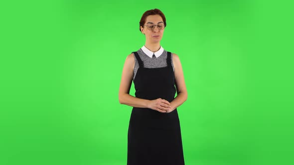 Funny Girl in Round Glasses Is Shyly Saying Wow and Smiling. Green Screen