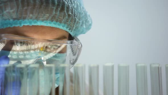 Scientist Examining Test Liquids in Tubes, Checking Chemical Reaction Behavior