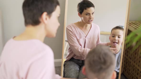 Boy Does Logopedic Exercises Opposite Mirror at Home