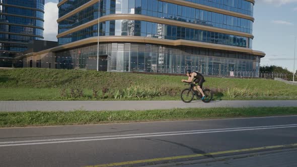 An Hardy Triathlete Rides a Bike Pro Cyclist Rides on a City Road Athlete Trains in an Urban