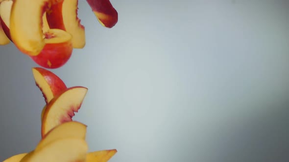 Peach Slices Fly Down on a White Background