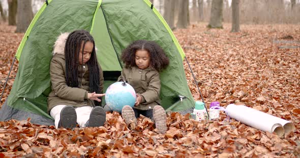 Black Race Kids Holding a Globe in an Autumn Forest