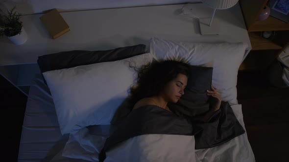 High Angle Shot of Young Woman Sleeping in Dark Bedroom