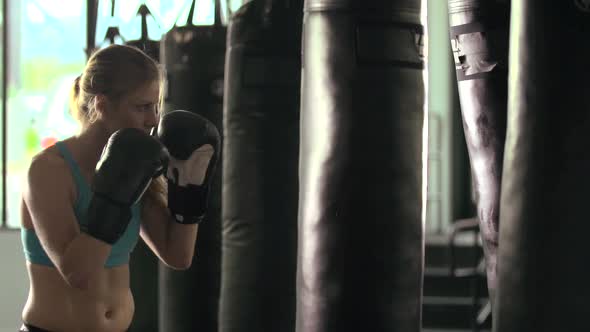 Woman does Muay Thai kickboxing training at the gym.