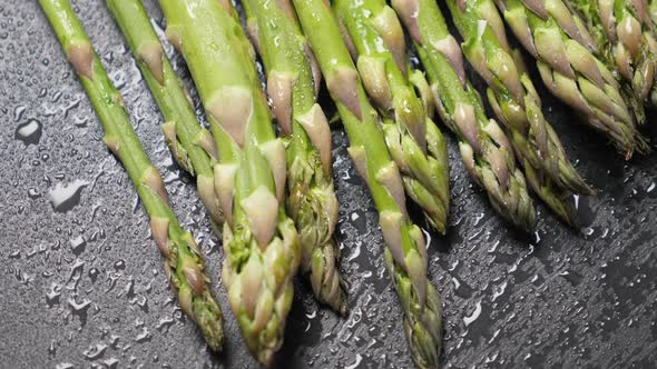 Raw Green Asparagus on Black Slate Background