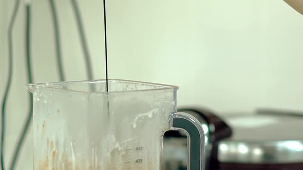 Cook Pours Hot Chocolate Into the Mixer with a Cocktail