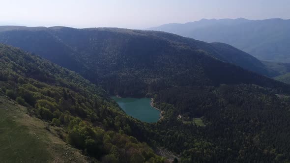 Lake among dense forests, aerial view.